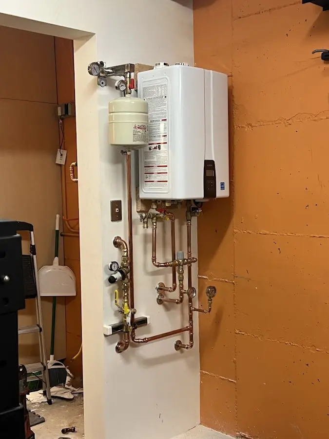 Plumbing technician inspecting water heater connections in Germantown